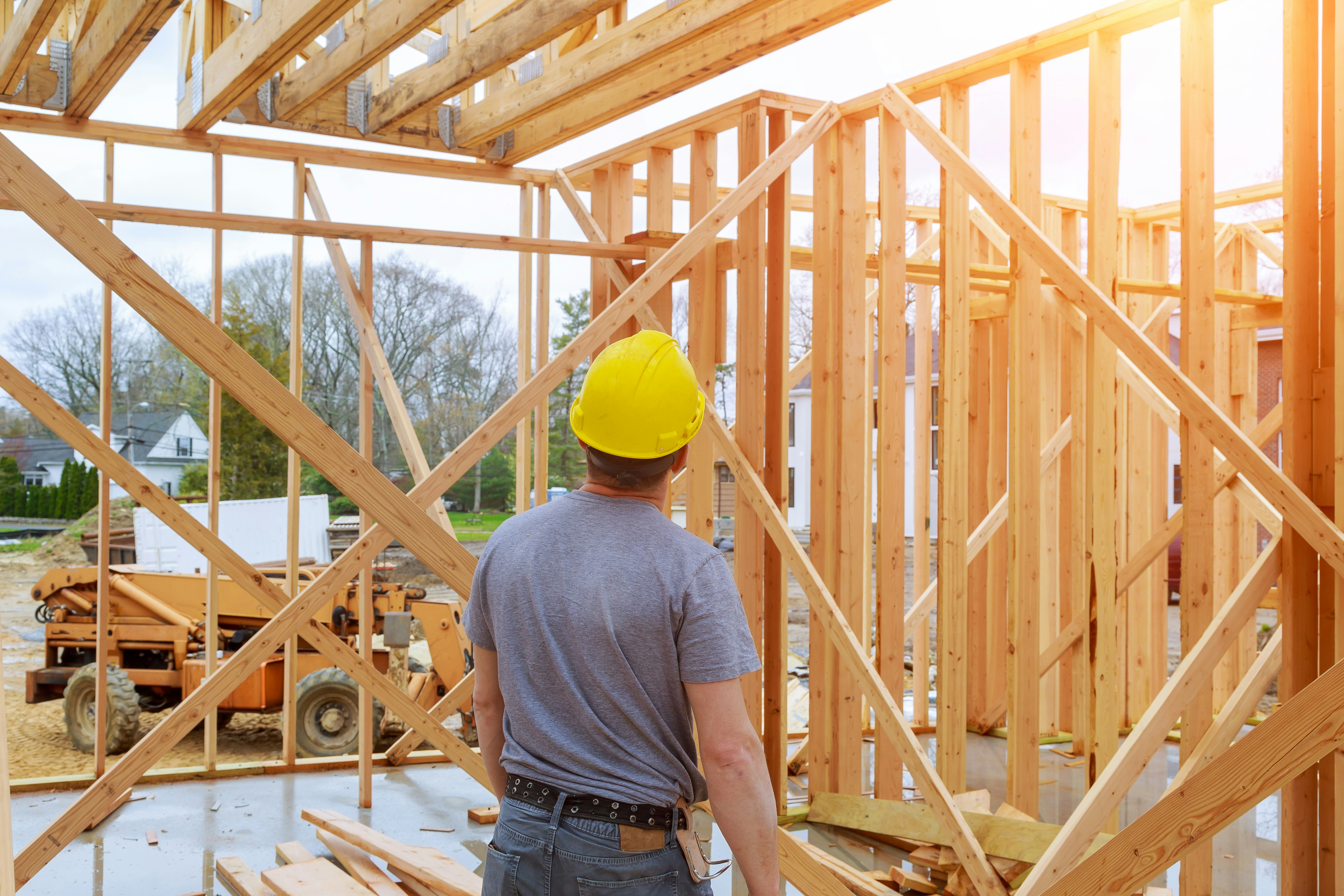 Construction worker with a hard hat standing in a building framework