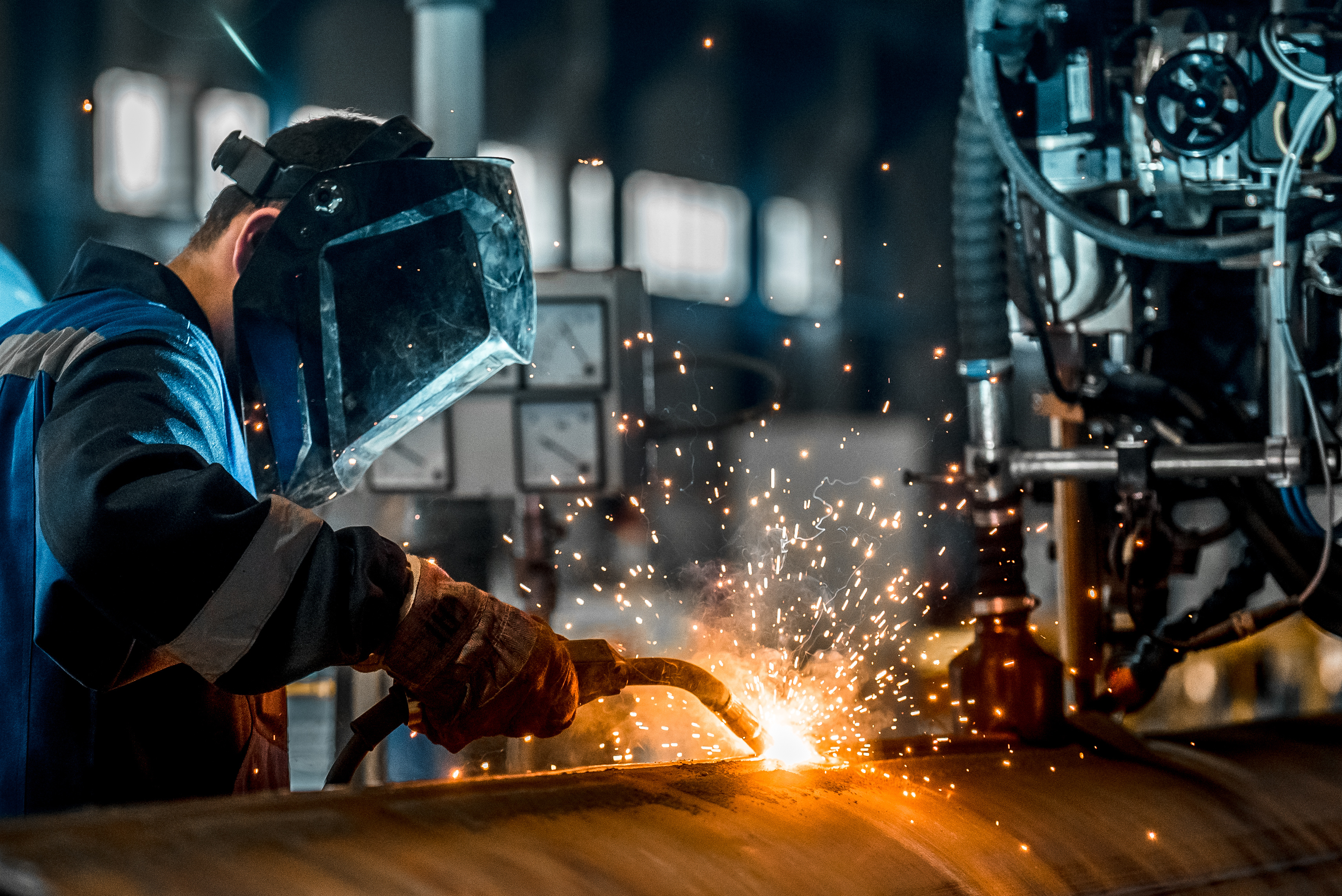 Man welding in a manufacturing facility.